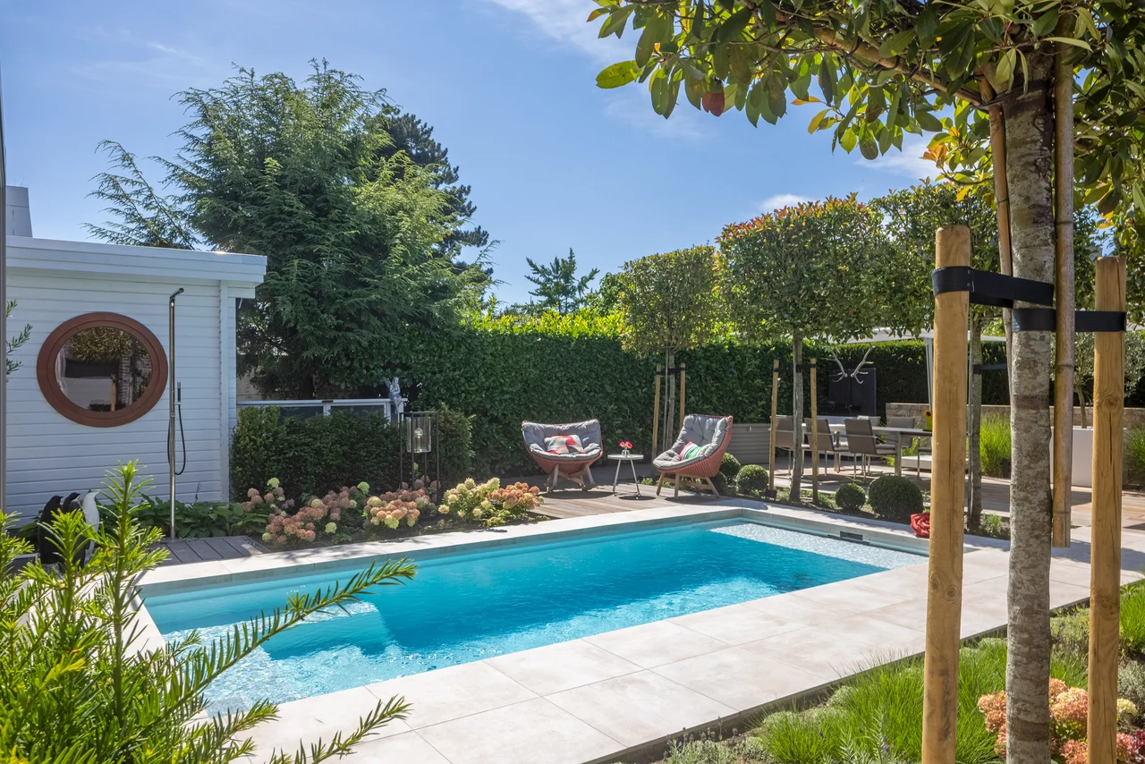 Covered jacuzzi area with seating and shade in a garden